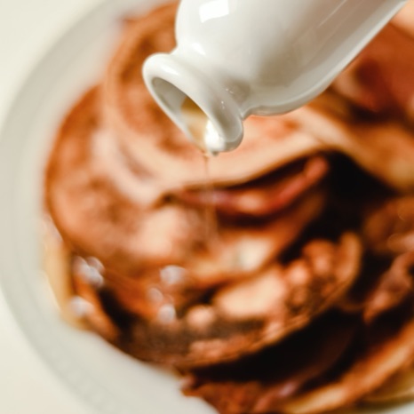Organic maple syrup being poured from a small pitcher